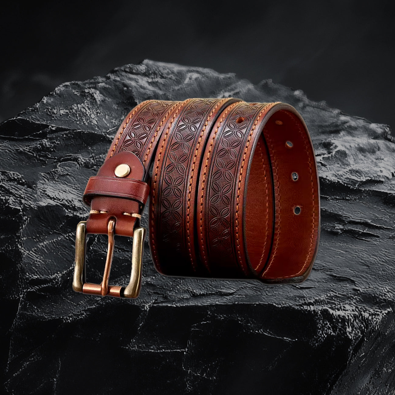 Echtleder-Gurt für Herren in Khaki – gerollt mit Metallschnalle auf schwarzem Steinfelsen