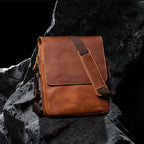 Umhängetasche aus Echtleder – schräge Frontansicht auf schwarzem Steinfelsen