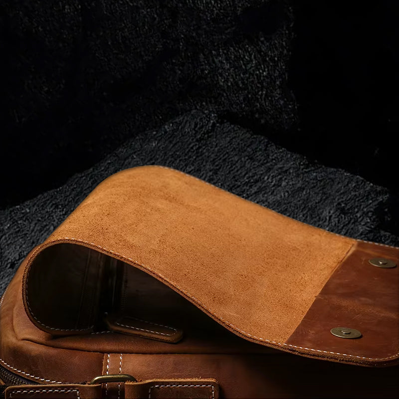 Umhängetasche aus Echtleder – geöffnete Ansicht auf schwarzem Steinfelsen