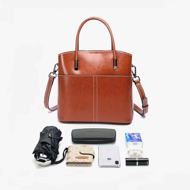 Echtleder Tasche Damen in Braun – Handtasche aus echtem Rindsleder mit Alltagsinhalt freigestellt auf weissem Hintergrund
