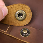 Druckknopf Detail an brauner Echtleder Tasche mit sauberer Ledernaht