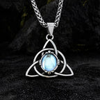 Halskette Damen mit Triquetra Knoten aus Edelstahl und blauem Stein auf dunklem Steinuntergrund