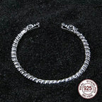 Wikinger Armring aus 925 Sterling Silber mit Wolfsköpfen und Echtheits-Prüfsiegel auf dunklem Hintergrund