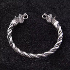 Wikinger Armring aus 925 Sterling Silber mit Drachenkoepfen und gedrehter Flechtung auf schwarzem Sand im nordischen Stil